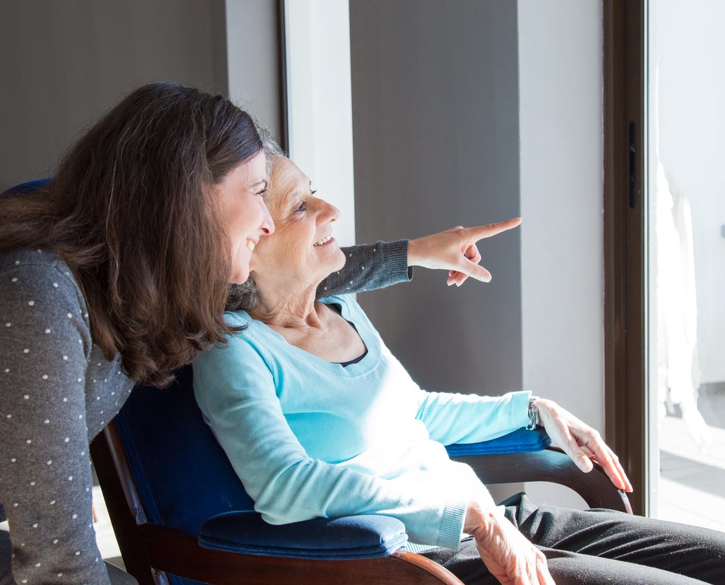 A carer and client sharing a warm moment together, looking out the window